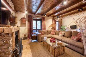 a living room with a couch and a fireplace at Pleta del Tarter 31A Lodge & SPA in Canillo