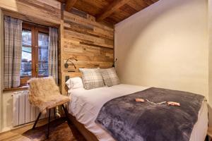 a bedroom with a bed and a chair and a window at Pleta del Tarter 31A Lodge & SPA in Canillo