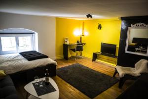 Pokój z łóżkiem, biurkiem i telewizorem w obiekcie Le Boudoir Secret w Besançon