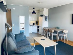 uma sala de estar e cozinha com um sofá e uma mesa em Ruoholahti Apartment with private sauna em Helsinque