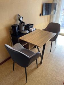 una mesa de madera y 2 sillas en una habitación en Le D'Artagnan - App 9 - Balcon, en Cazaubon