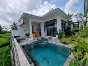eine Villa mit einem Pool vor einem Haus in der Unterkunft Villa Padang Santhi in Ubud