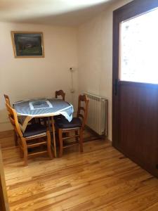 a dining room with a table and chairs and a door at Apartamento Forn de Serra in Lladorre