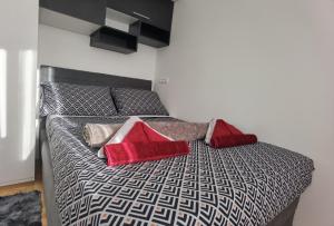 Un dormitorio con una cama con almohadas rojas. en Aki, en Podstrana