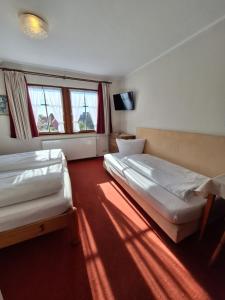 a room with two beds and a window at Hotel Zum Breiterle in Rothenburg ob der Tauber