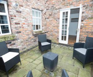 eine Gruppe von Stühlen und Tischen auf einer Terrasse in der Unterkunft Spacious house Liverpool city centre L1, sleeps 16 in Liverpool