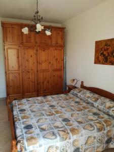 - une chambre avec un grand lit et une armoire en bois dans l'établissement Casa Lisa, à San Vito Lo Capo
