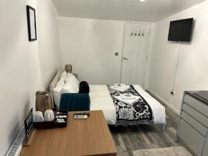 Kleines Zimmer mit einem Bett, einem Tisch und einem TV. in der Unterkunft Ana guest house in Hookwood