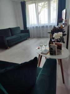 a living room with a couch and a table with wine glasses at Kawalerka apartament ul gieldowa in Kołobrzeg