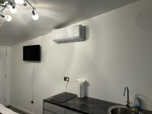 een keuken met een wastafel en airconditioning aan de muur bij Ana guest house in Hookwood