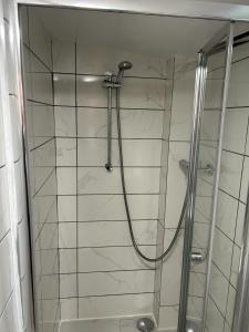 a shower with a glass door in a bathroom at Ana guest house in Hookwood