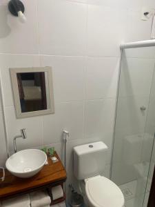 a bathroom with a toilet and a sink and a shower at Pousada Morada do Sol in Camocim