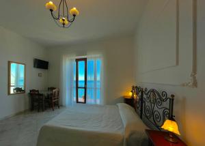 1 dormitorio con cama y lámpara de araña en Residenza Porta di Mare, en Castellabate