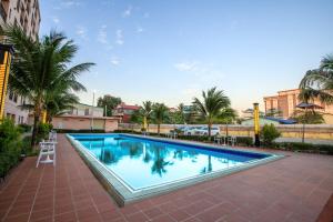 uma grande piscina com palmeiras em redor em Notis International Hotel 诺蒂斯国际酒店 em Phnom Penh