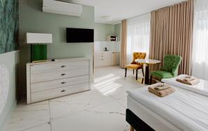 a hotel room with a bedroom with a bed and a tv at Meduza Sopot in Sopot