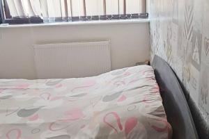 a bed with pink hearts on it in a bedroom at Cosy house close to London Bridge in London