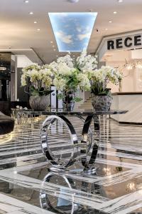 a lobby with a table with vases of flowers on it at Prestige Hotel and Aquapark - All inclusive in Golden Sands +255 photos