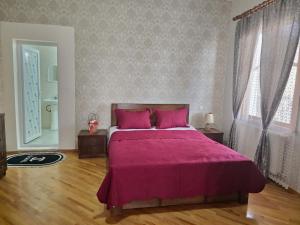 ein Schlafzimmer mit einem großen Bett mit rosa Bettwäsche in der Unterkunft My home in Kutaissi
