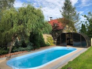 - une piscine dans une cour à côté d'une maison dans l'établissement Komfortables Ferienhaus in Meszna Opacka mit Privatem Pool, à Meszna Opacka