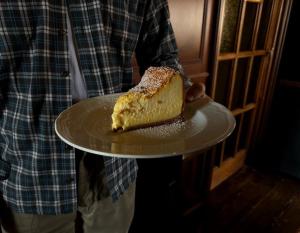 una persona sosteniendo un pedazo de pastel en un plato en Hotel Hermitage, en Florencia