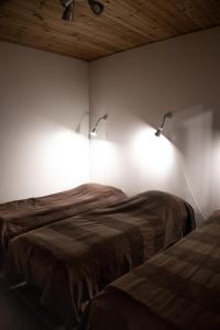 a bedroom with two beds and two lights on the wall at Ameno 3 Himos by DG Lomailu in Jämsä