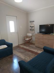 a living room with a couch and a television at Skala Central House in Skala
