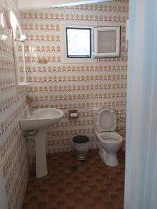 a bathroom with a sink and a toilet and a window at Skala Central House in Skala