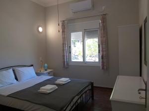 - une chambre avec un lit et 2 serviettes dans l'établissement Skala Central House, à Skala