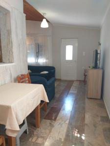 a living room with a blue couch and a table at Skala Central House in Skala