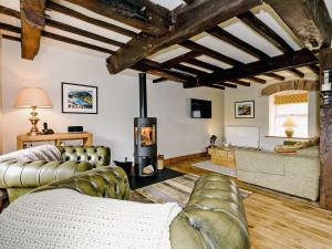 a living room with a couch and a fireplace at The Old Mill in Hackthorpe