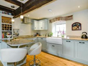 a kitchen with white cabinets and a large island at The Old Mill in Hackthorpe