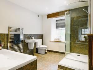 a bathroom with a toilet and a sink and a shower at The Old Mill in Hackthorpe