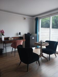 sala de estar con mesa, sillas y piano en Touraco, en Villars-les-Dombes