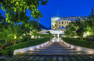 un conjunto de escaleras en un jardín por la noche en La Medusa Hotel - Dimora di Charme en Castellammare di Stabia