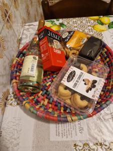 una cesta de comida y una botella de vino en una mesa en Casa rosario e annamaria, en Torri del Benaco