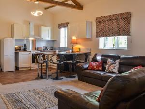 a kitchen and living room with a couch and a table at Barnby Barn 1 - Uk43808 in Bossall