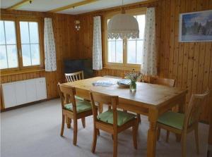 uma sala de jantar com uma mesa de madeira e cadeiras em Tanzhus em Wildhaus