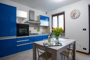 una cucina con armadi blu e tavolo con sedie di La bella casa di Roberta a Illasi