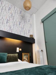 a bedroom with a bed and a wall with flowers at Hôtel Abalone - Centre Gare in Nîmes