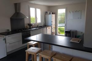 a kitchen with a black counter top and a stove at Le paradis des enfants in La Jarrie