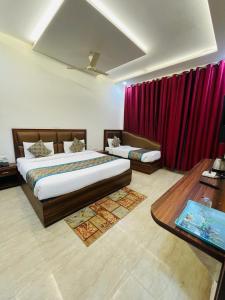 a bedroom with two beds and a red curtain at Hotel The Golden Taj By The Golden Taj group & Hotels in Agra