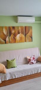 un sofá blanco en una habitación con una pintura de donuts en Bonito bajo cerca del mar, en Benicarló