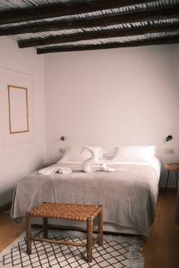 una camera con letto e panca in legno di Riad Bianca Essaouira Guest House a Essaouira