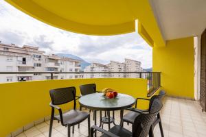 uma mesa e cadeiras numa varanda com uma parede amarela em Apartment UR em Bar