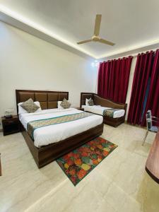 a bedroom with two beds and a ceiling fan at Hotel The Golden Taj By The Golden Taj group & Hotels in Agra