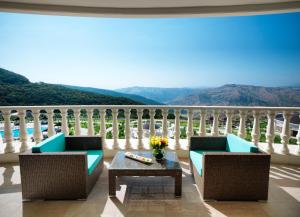 Un balcón con 2 sillas y una mesa con vistas. en Shamakhi Palace Sharadil, en Şǝrǝdil