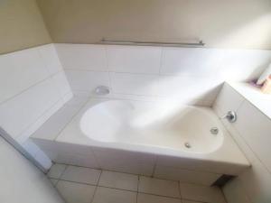 uma banheira branca numa casa de banho branca em Remarkable 2-Bed Apartment in Harare em Harare