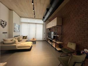 a living room with a couch and a brick wall at U Park 1-BR in Sin El Fil in Beirut