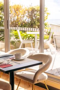 uma mesa e cadeiras numa varanda com uma chávena de café em Hotel Ker Moor Saint-Quay Portrieux em Saint-Quay-Portrieux