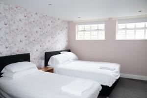 two beds in a room with pink wallpaper at Spacious house Liverpool city centre L1, sleeps 16 in Liverpool